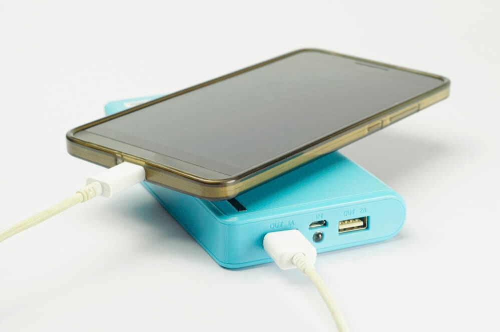 carregador portátil azul carregando telefone celular com capa