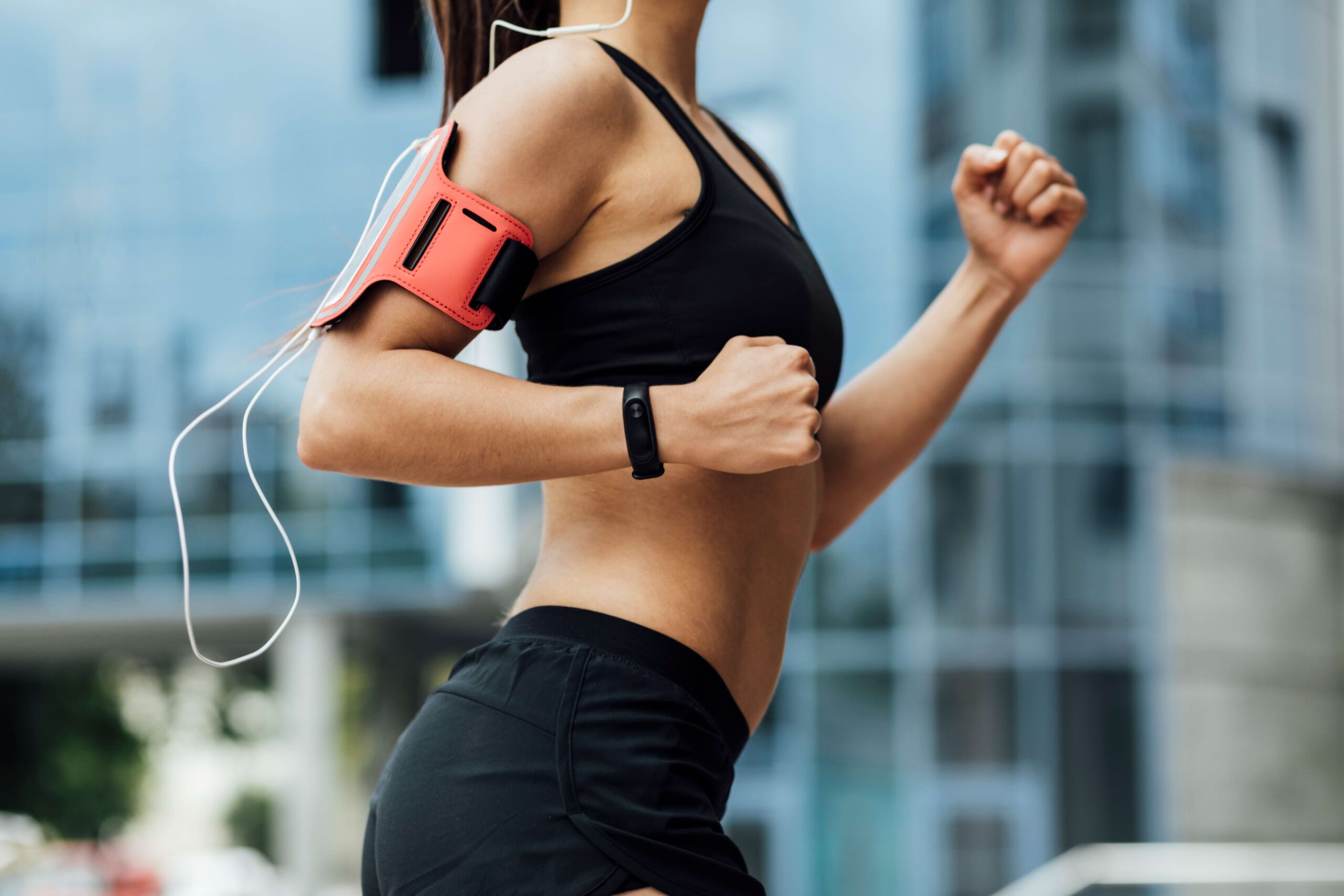 Vista lateral de mulher correndo usando um smartwatch