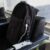 Mochila antifurto da GShield em cima de cadeira no aeroporto ao lado de iPhone branco com capa preta e transparente