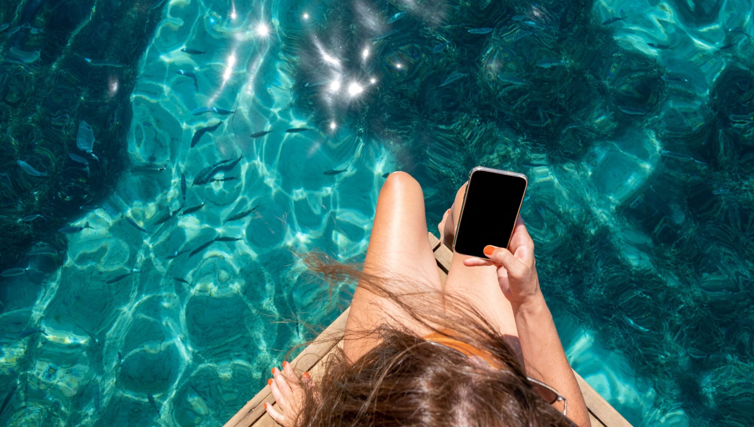 Mulher com celular na piscina